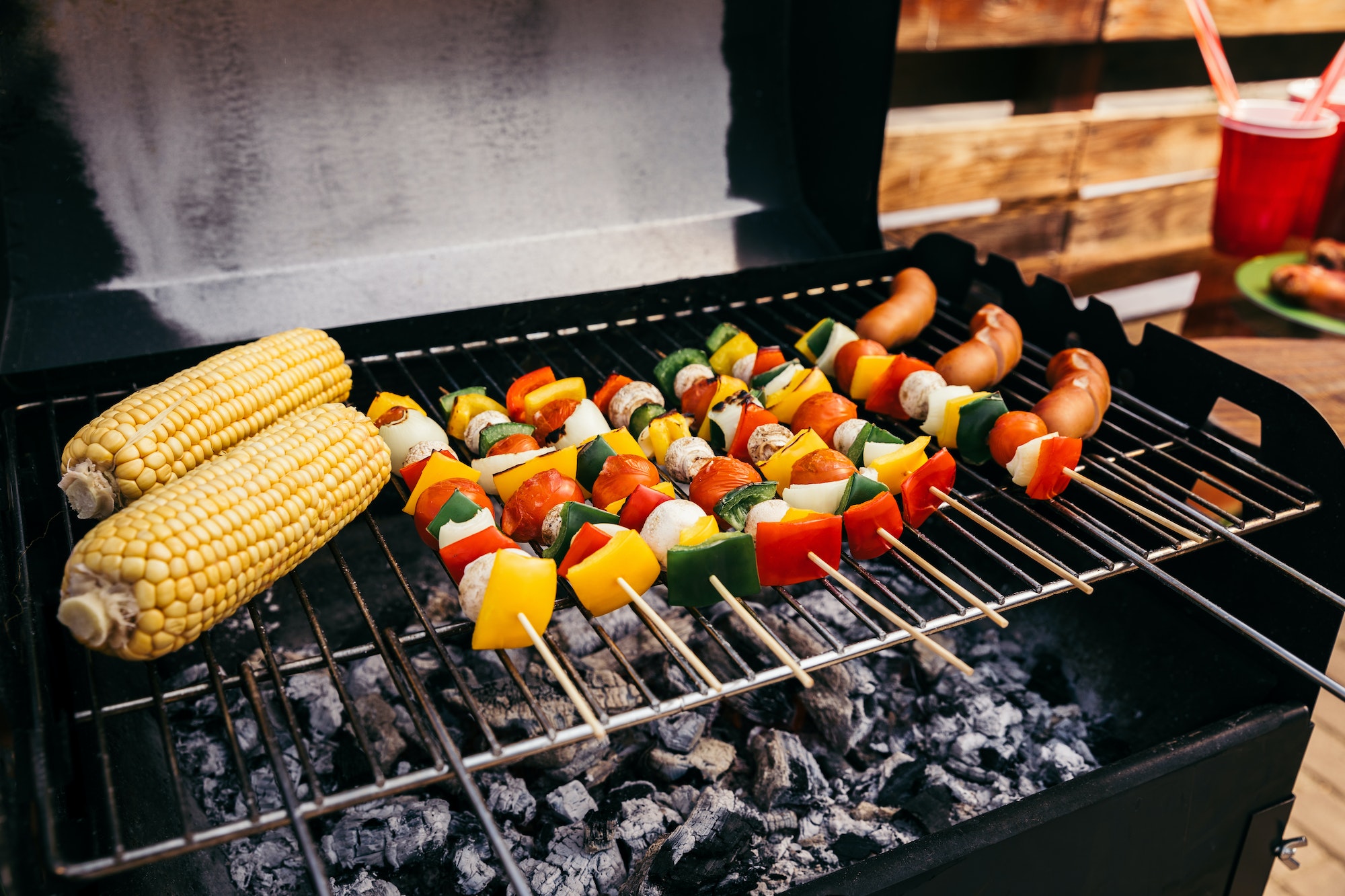 Corn and vegetables grilled for outdoors barbecue with sausages